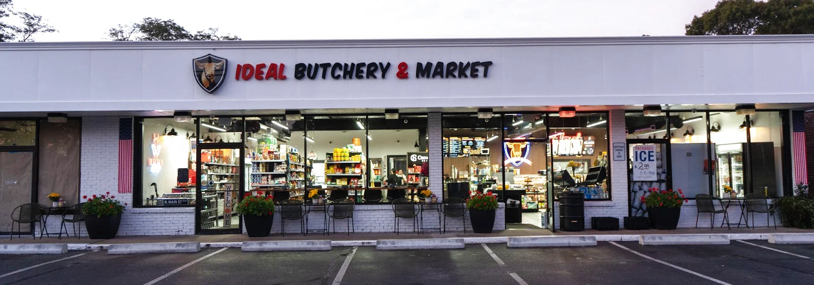 Ideal Butchery & Market at 213 W Main Street, Hyannis — the lit storefront at closing time, the shelves and the butcher counter visible through the window